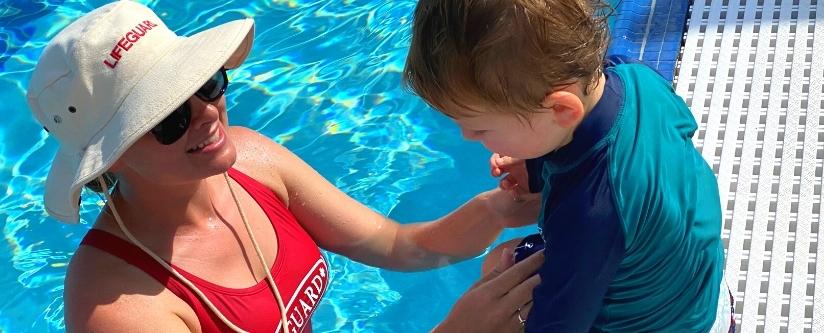 Female instructor teaching child how to swim