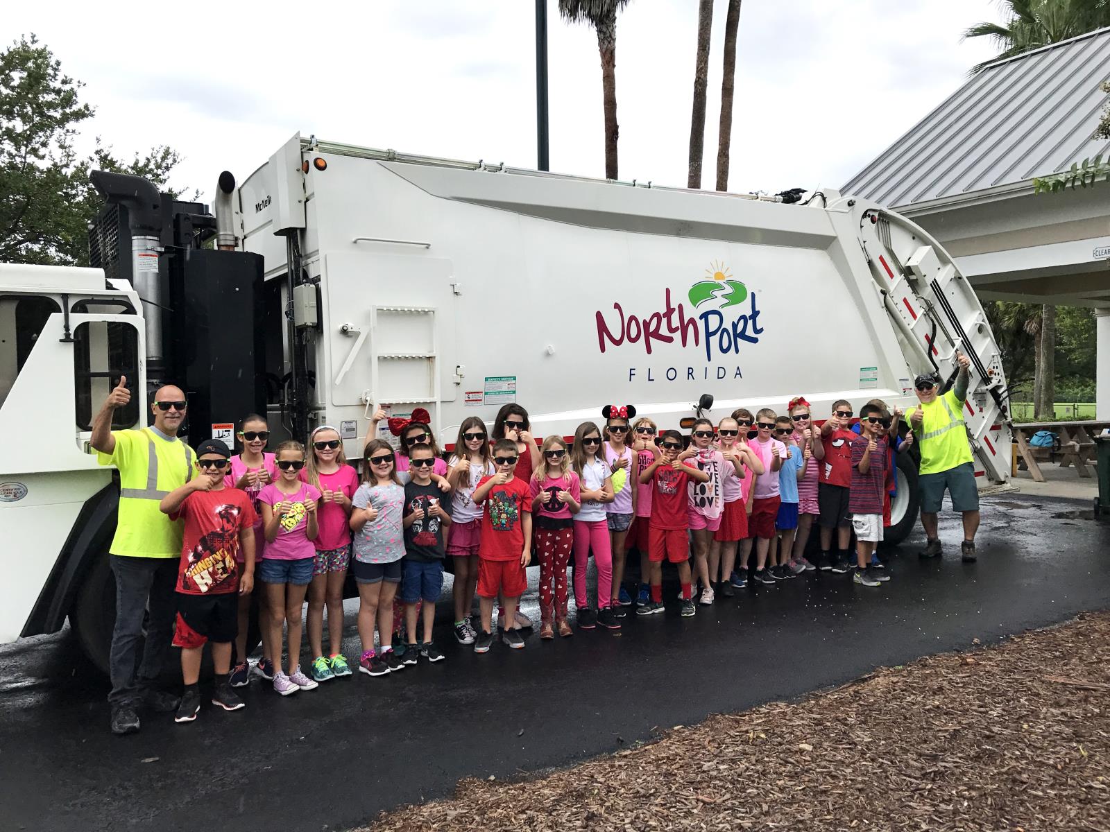 Children standing by a waste collection truck