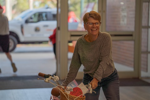 Woman walking a bike through a hallway